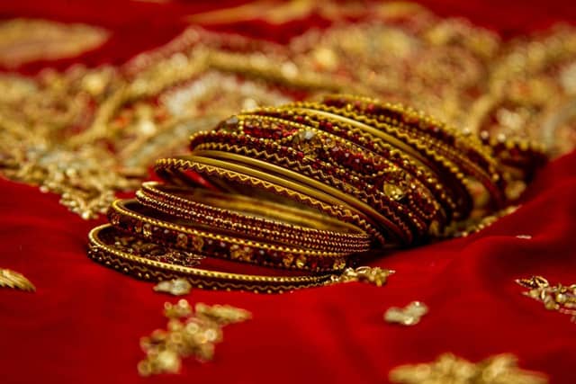 Gold bangles on red embroidered fabric